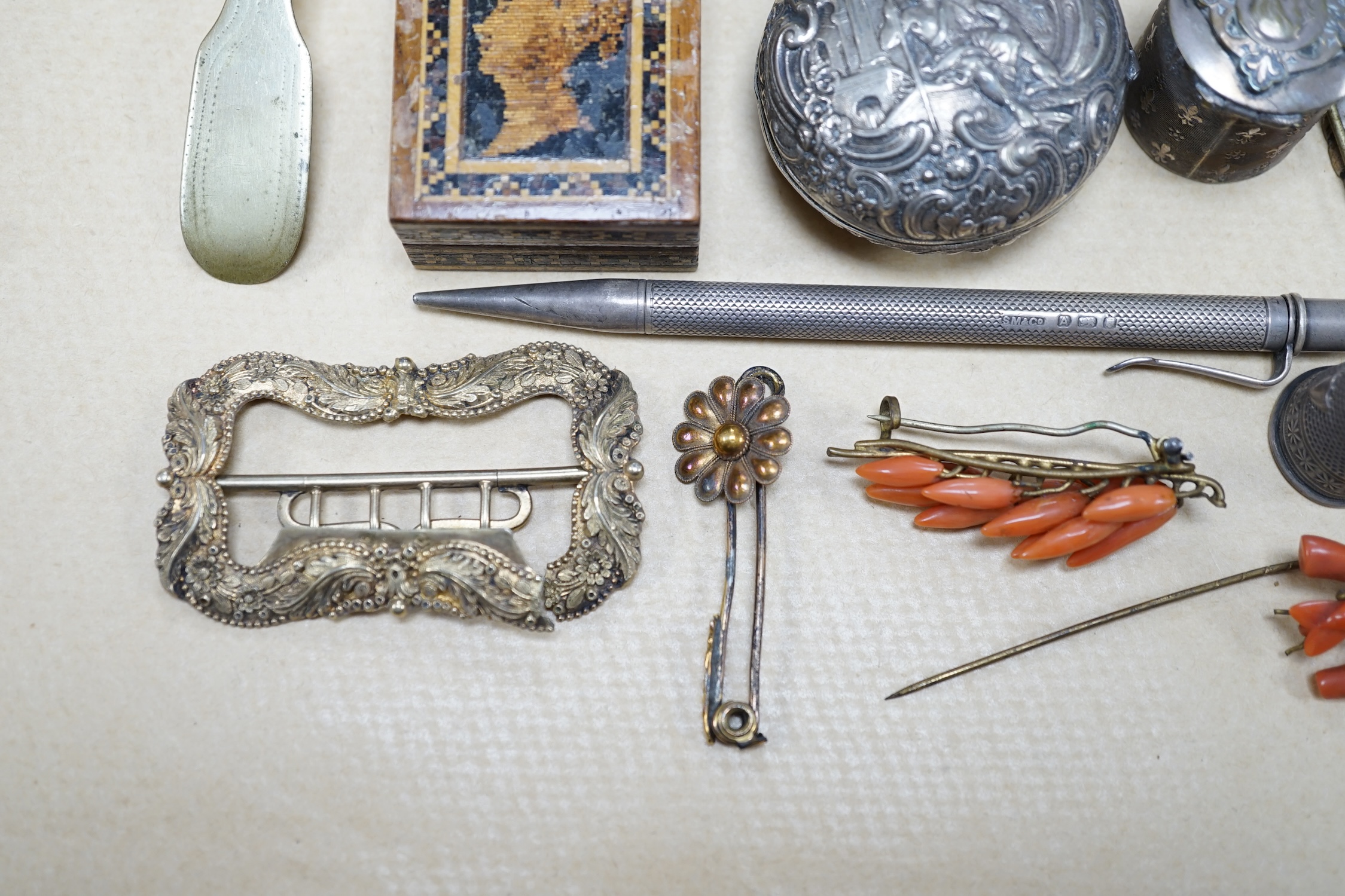 Objects of vertu and jewellery to include a carved coral stick, a pair of miniature candlesticks, a gilt metal shoe buckle, a Scottish hardstone anchor brooch and a Tunbridge ware stamp case. Condition - varies